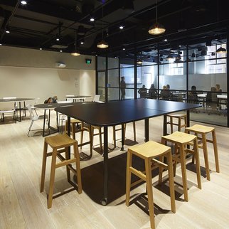 Tall Versatilis table with stools in an office setting