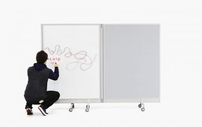 Man writes ideas on Muzo's Flow portable, folding wall