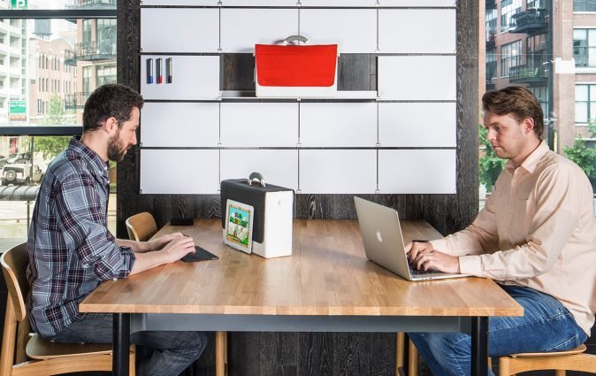 Man works from tablet supported by HB-Two personal storage box